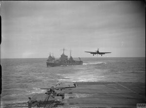 A Fairey Fulmar about to land on the flight deck of HMS Victorious at Hvalfjord. The American cruiser USS Wichita (CA-45) is astern.jpg